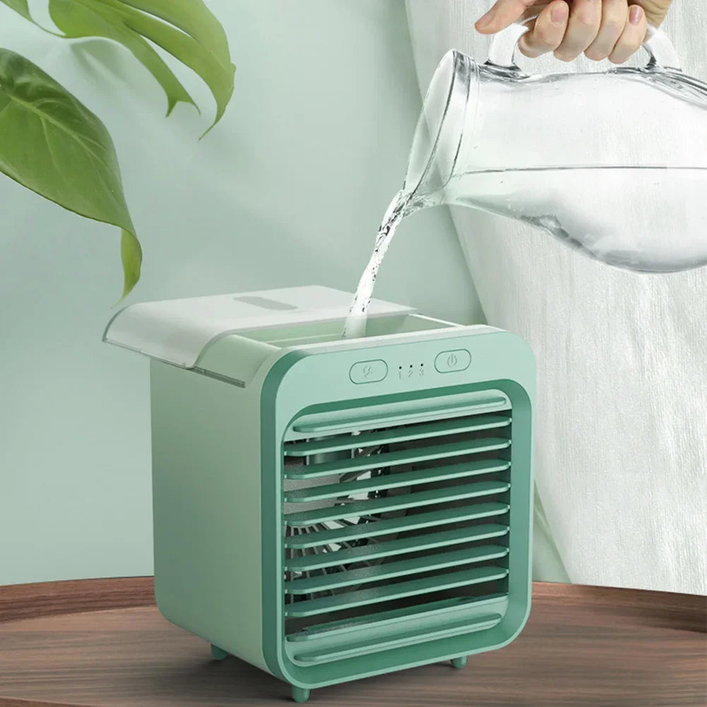 Light green rechargeable mini air cooler and humidifier being filled with water, showing its compact design.