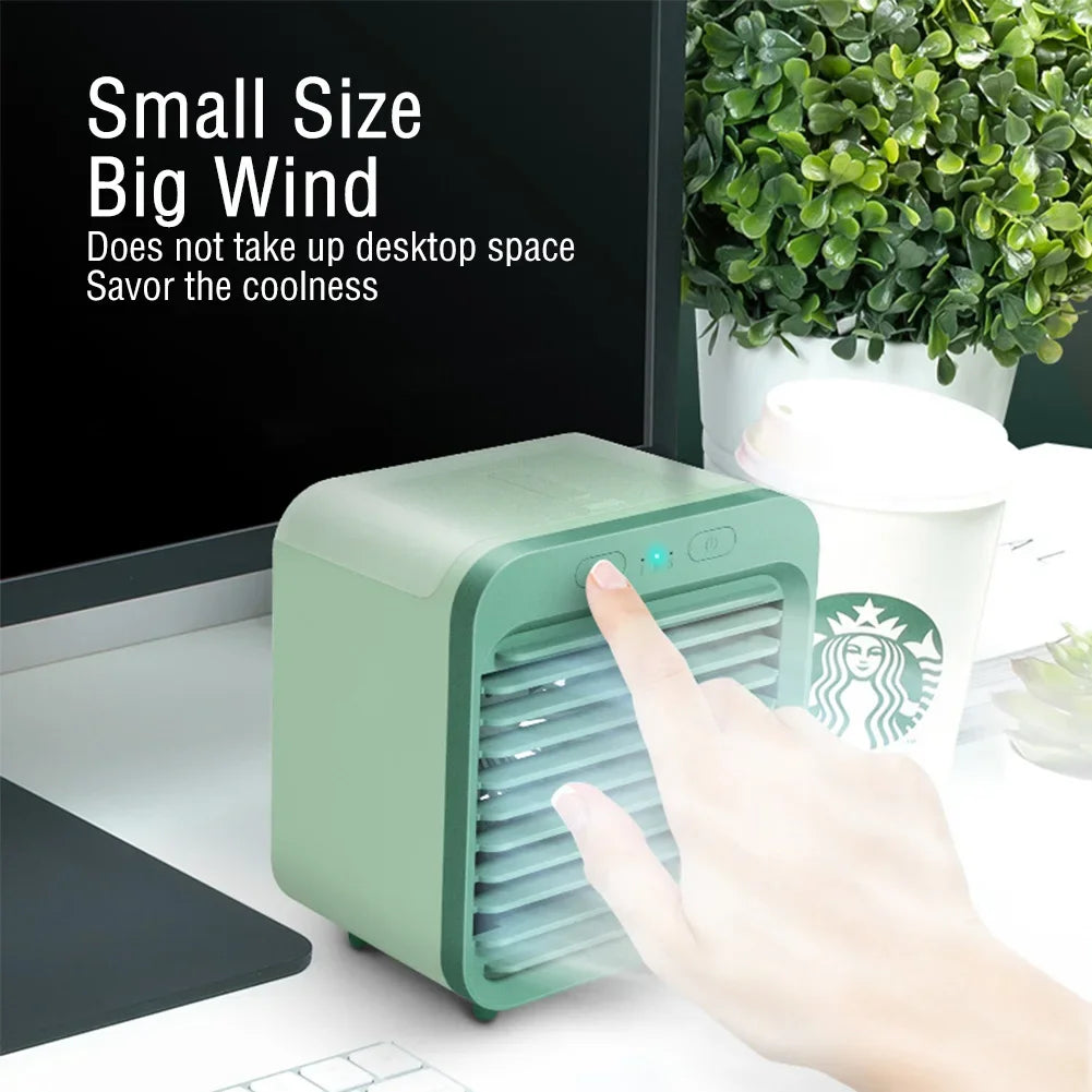Green rechargeable mini air cooler and humidifier on a desk, being touched by a finger.